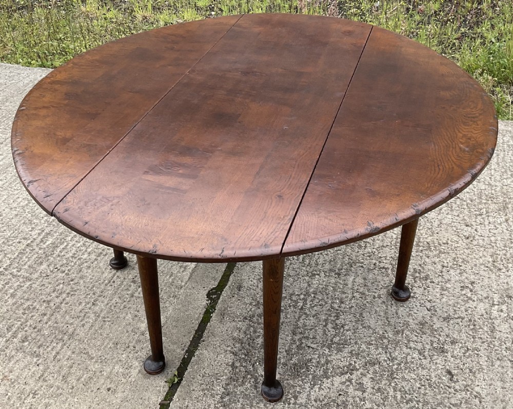 A large oval mahogany dropleaf dining table with tapered legs terminating in pad feet. View III
