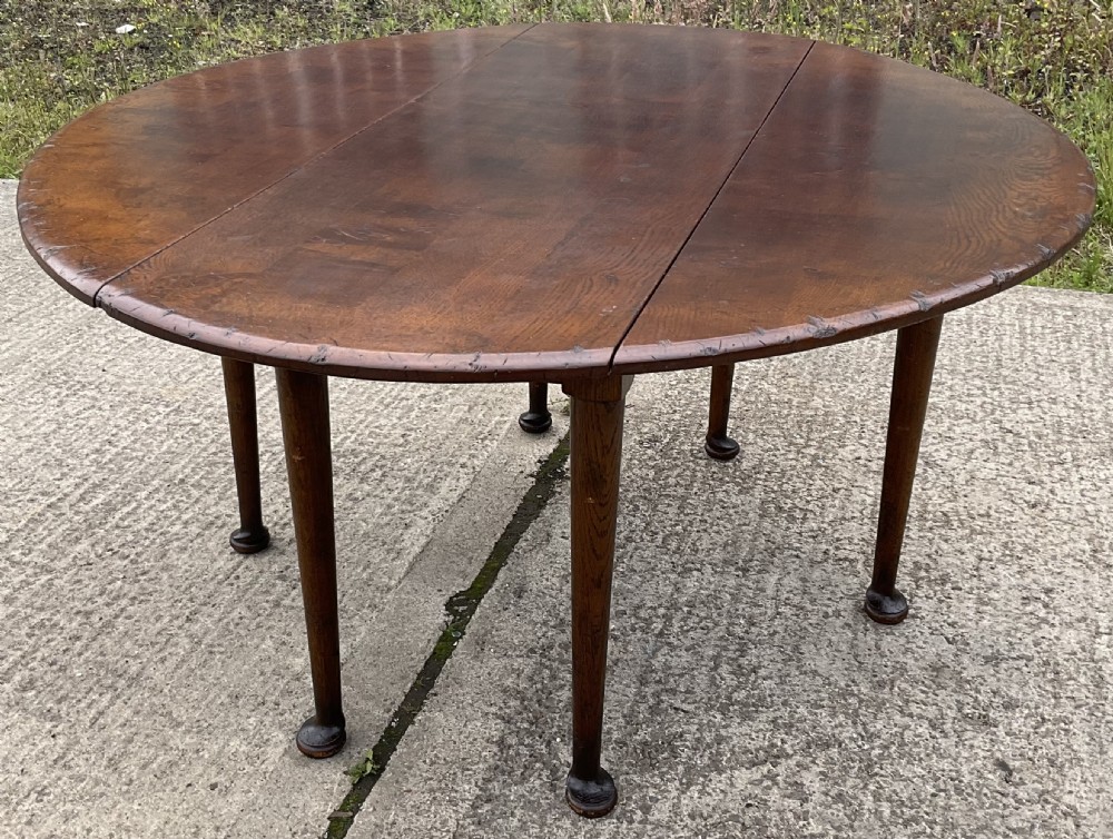 A large oval mahogany dropleaf dining table with tapered legs terminating in pad feet. View IV