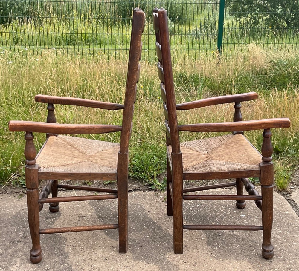 A set of six warm brown wood ladderback dining chairs with hand-woven rush seats, comprising four side chairs and two carver armchairs. View VIII