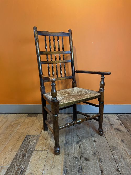 An Edwardian Rush Seated Oak Spindle Back Open Armchair