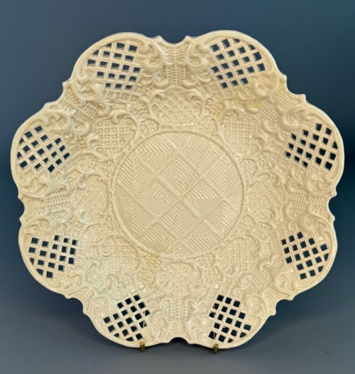 fig 1. An 18th-century cream-coloured Staffordshire saltglaze stoneware lobed plate featuring lattice piercing and relief-moulded scrollwork details.