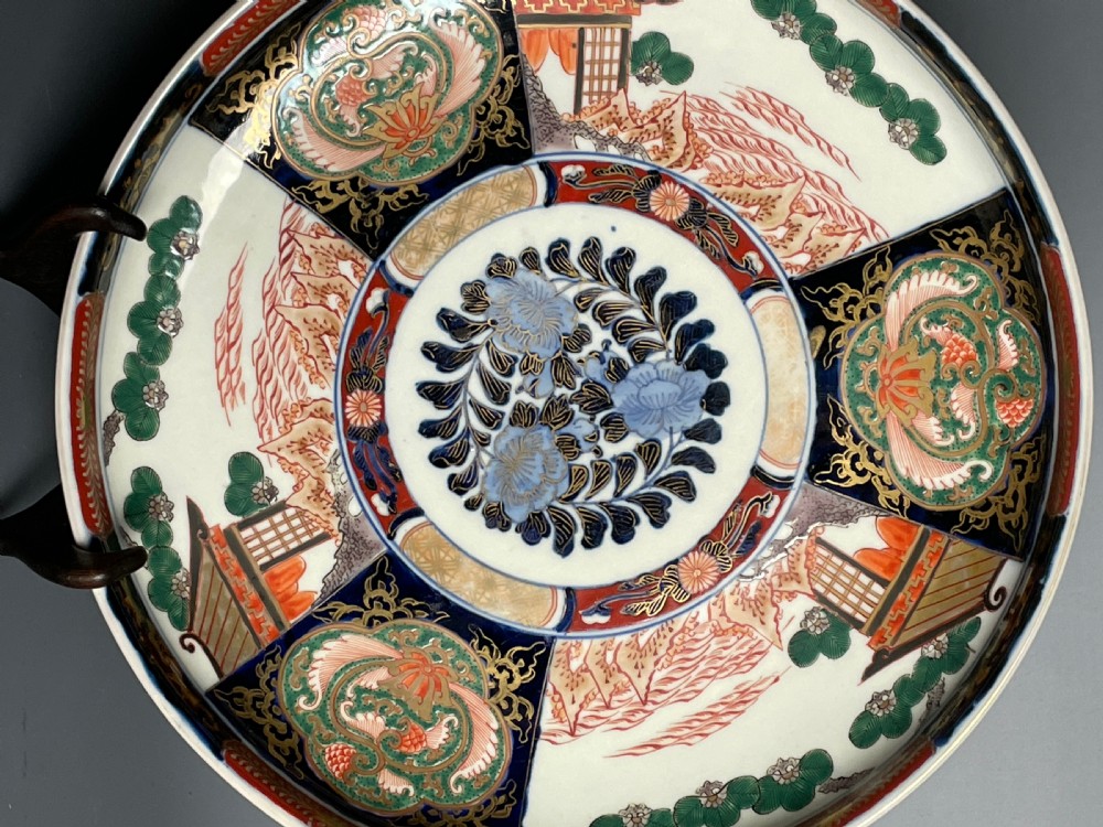 A large circular Japanese Imari porcelain shallow bowl featuring detailed panelled motifs in cobalt blue, iron-red, green, and gold hand-painted enamel. View II