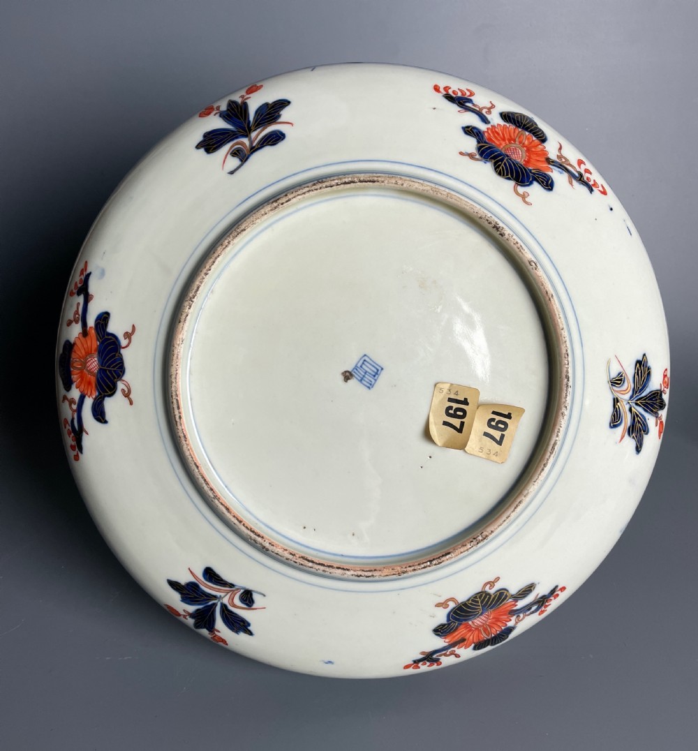 A large circular Japanese Imari porcelain shallow bowl featuring detailed panelled motifs in cobalt blue, iron-red, green, and gold hand-painted enamel. View V