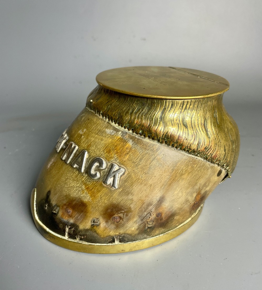 A Victorian horse hoof inkwell featuring brass mounts, a hinged brass lid, and silver lettering reading NICK-NACK. View II