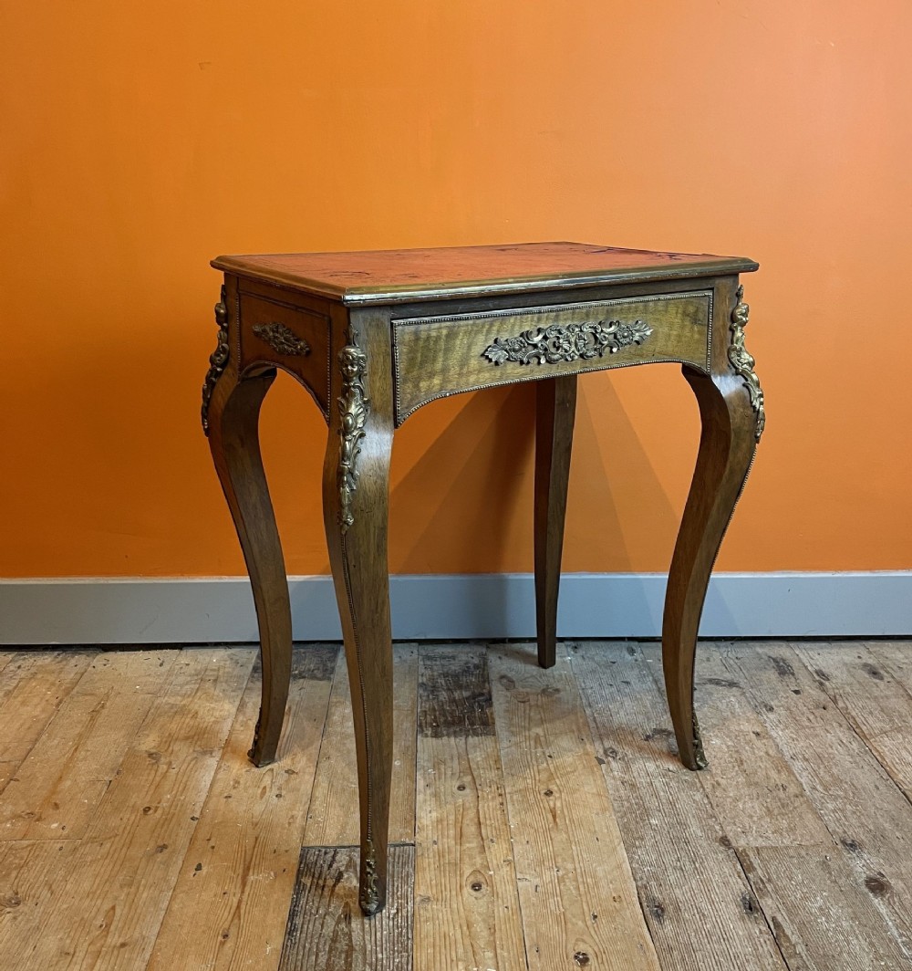 An antique French Louis XV Revival side table with cabriole legs, decorative gilt bronze ormolu mounts, and a rectangular inset top.
