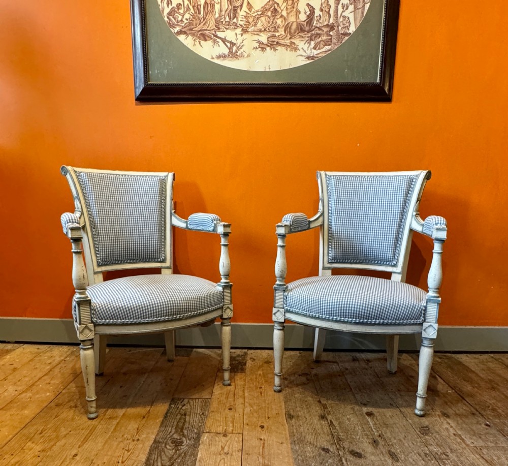 Pair of vintage French armchairs featuring off-white distressed painted frames, fluted turned front legs, and blue and white checked fabric upholstery. View III