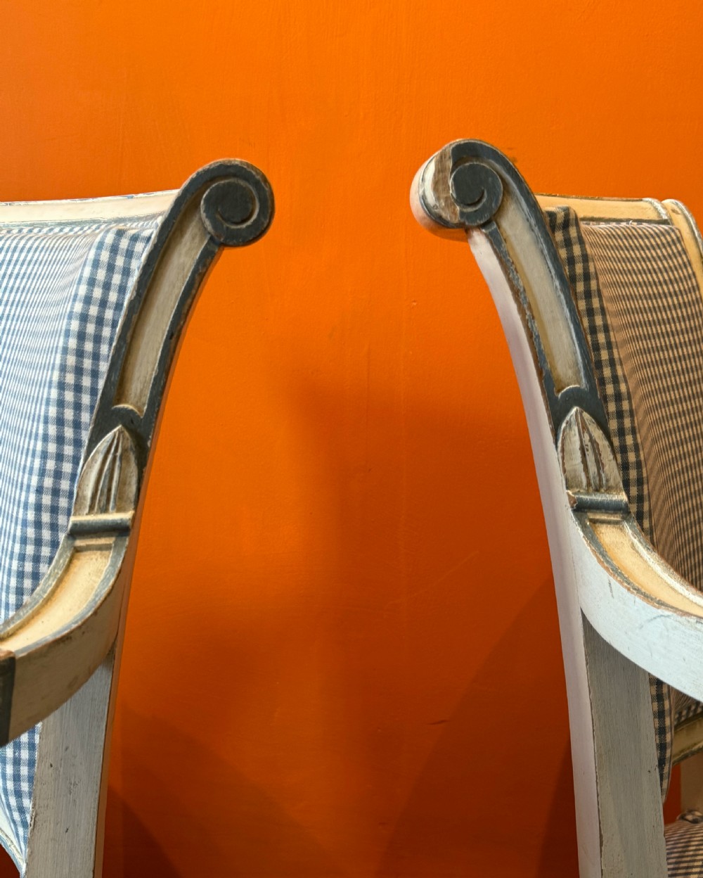 Pair of vintage French armchairs featuring off-white distressed painted frames, fluted turned front legs, and blue and white checked fabric upholstery. View VI