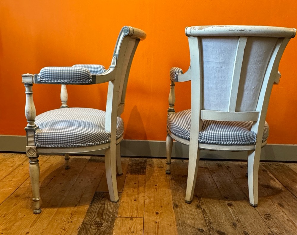 Pair of vintage French armchairs featuring off-white distressed painted frames, fluted turned front legs, and blue and white checked fabric upholstery. View VII