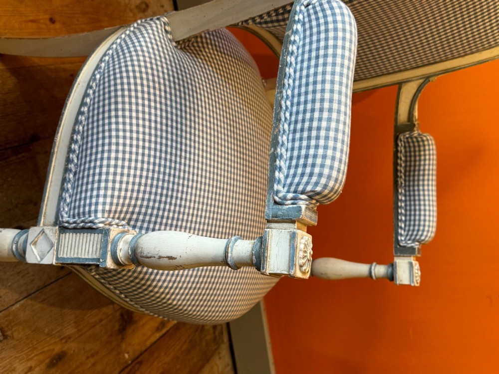 Pair of vintage French armchairs featuring off-white distressed painted frames, fluted turned front legs, and blue and white checked fabric upholstery. View VIII