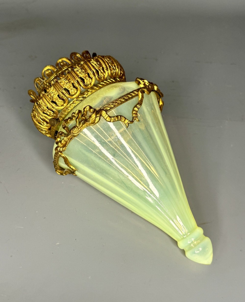 A cone-shaped green vaseline glass lampshade fitted with ornate cast brass gallery mounts and decorative metal trim.