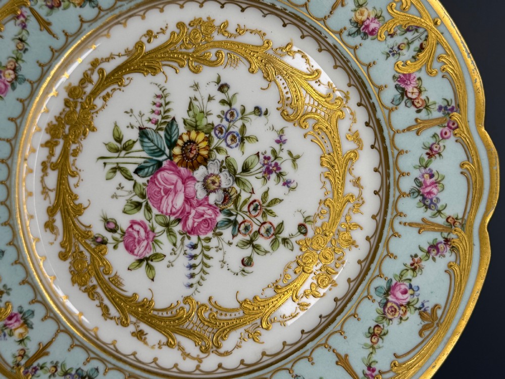 A circular 19th-century French porcelain cabinet plate featuring central hand-painted floral bouquets framed by elaborate gold scrollwork and a turquoise border. View II