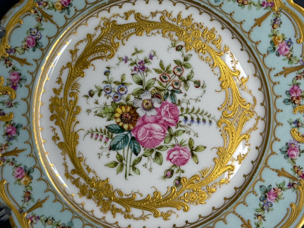 A circular 19th-century French porcelain cabinet plate featuring central hand-painted floral bouquets framed by elaborate gold scrollwork and a turquoise border. View III