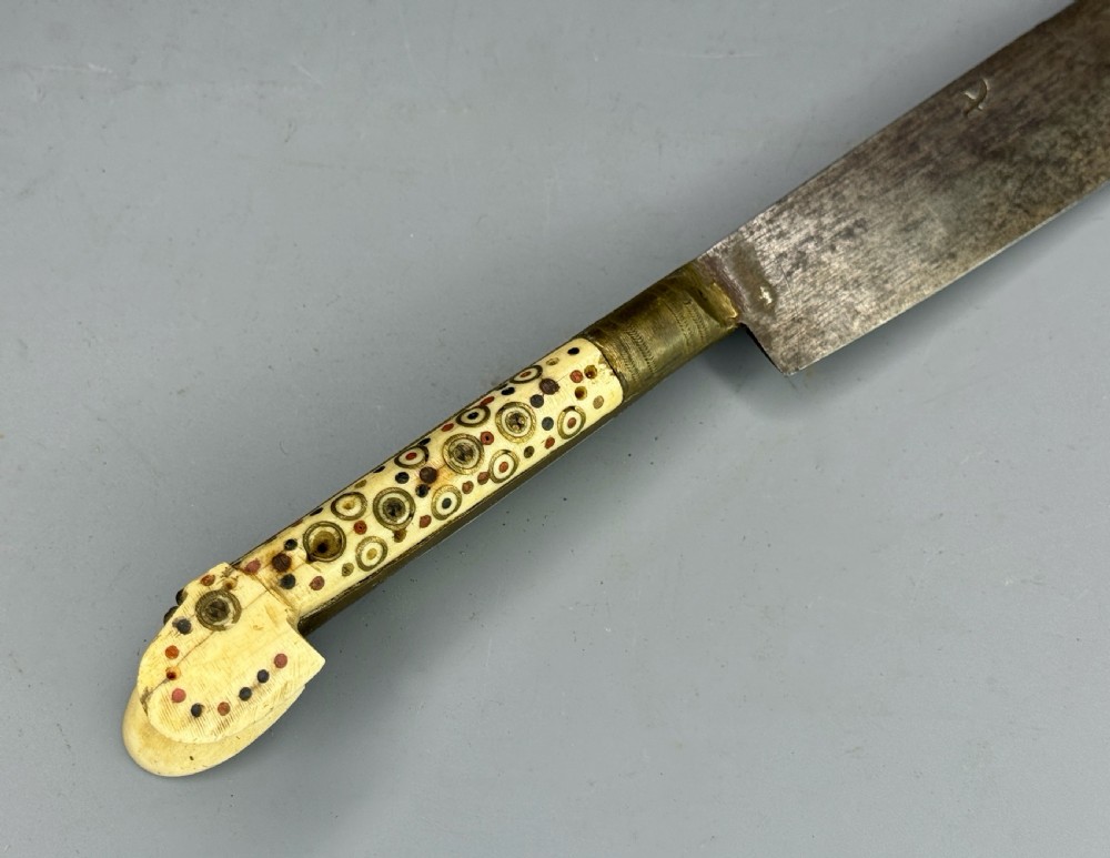 An antique nineteenth-century Balkan dagger featuring a curved steel blade and an off-white bone handle decorated with circular brass pin motifs. View III