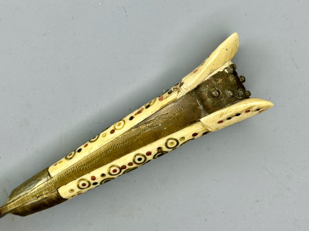 An antique nineteenth-century Balkan dagger featuring a curved steel blade and an off-white bone handle decorated with circular brass pin motifs. View VI