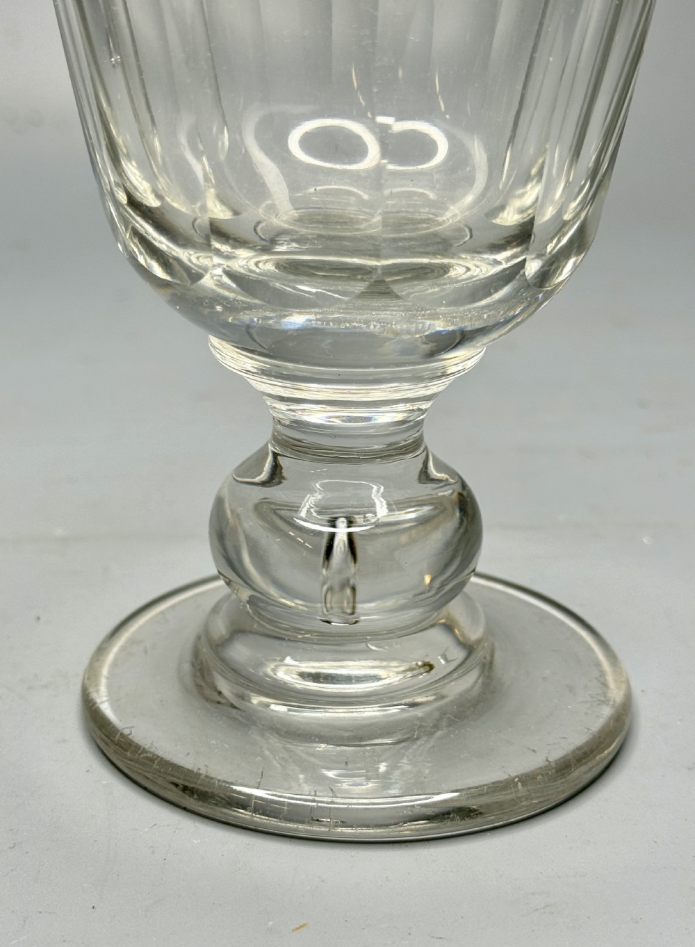 A clear Victorian glass rummer featuring a slice-cut bowl, a knopped stem, and a flat circular base. View IV