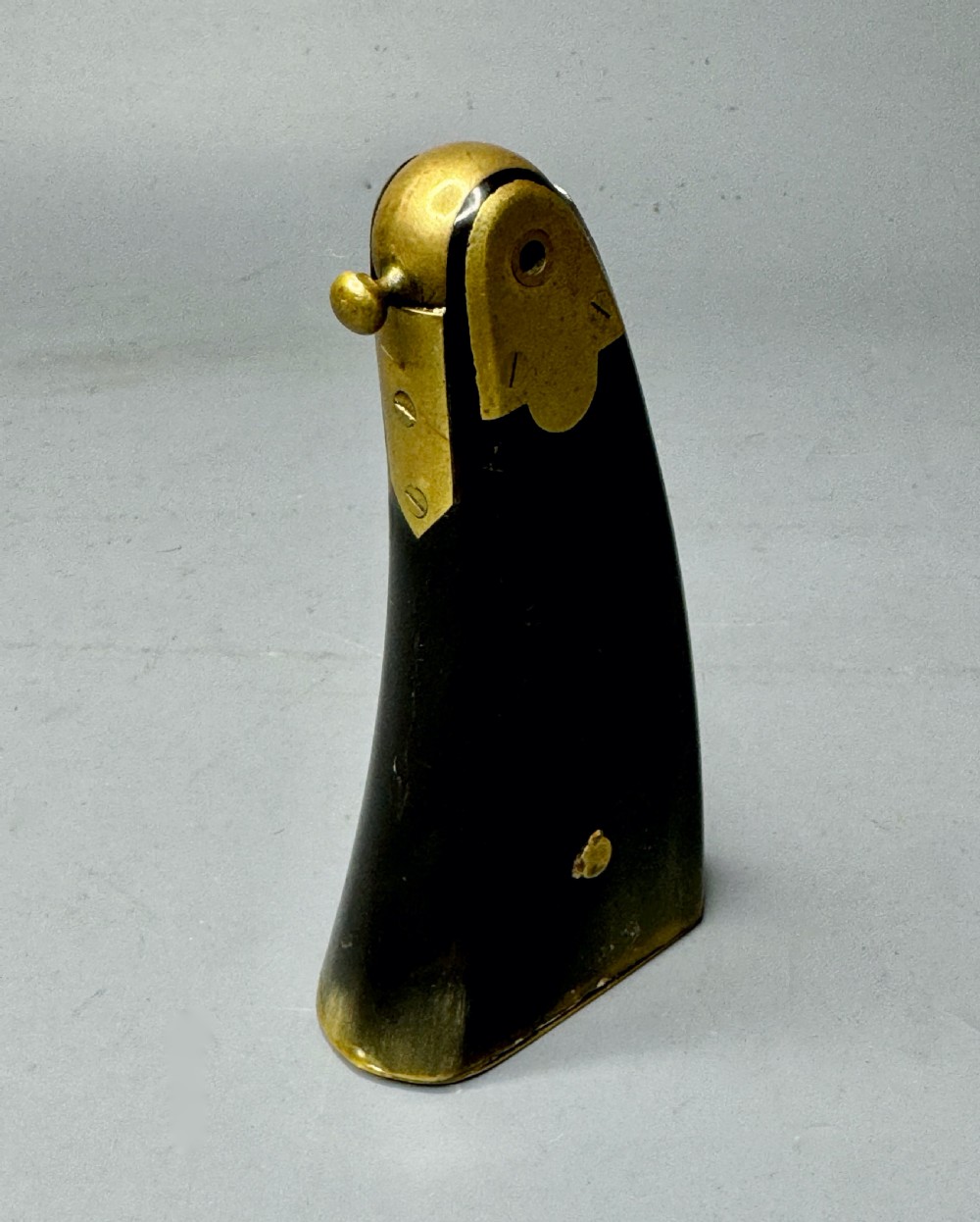 A curved dark horn priming flask fitted with polished brass mounts and a small brass dispensing valve.