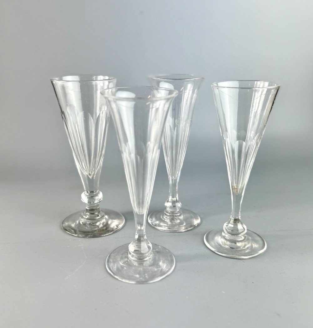 A harlequin set of four antique cut glass champagne flutes