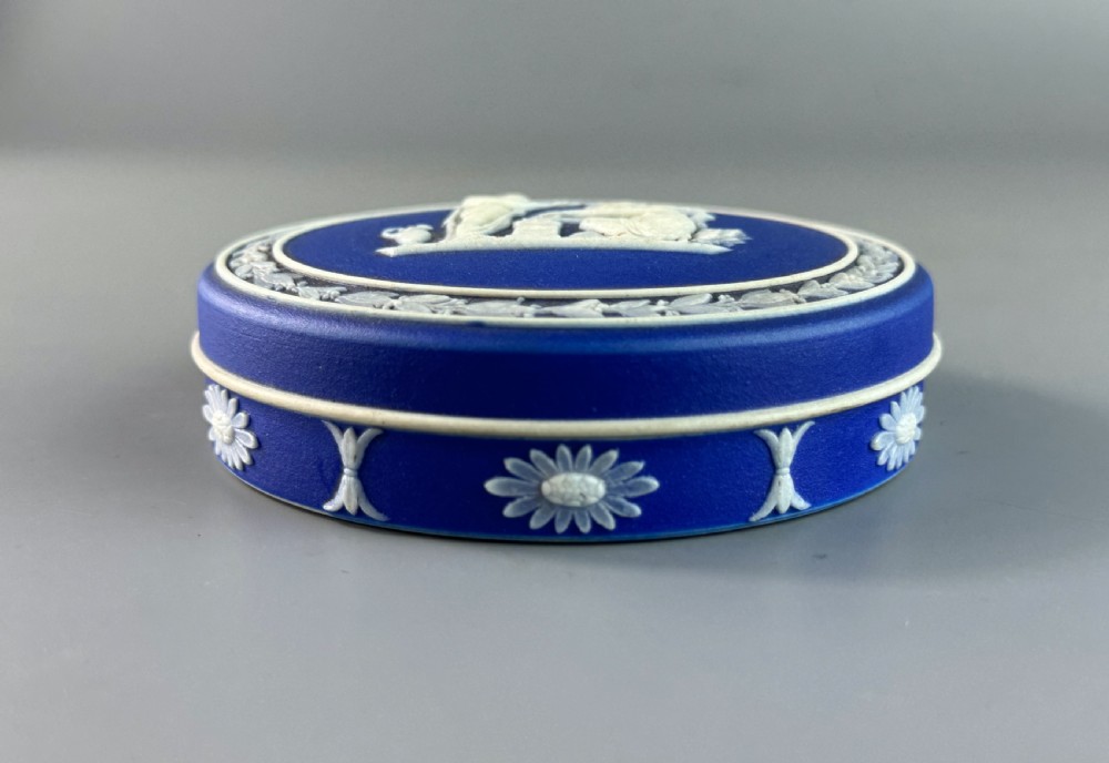 A circular royal blue jasperware patch box featuring white neoclassical relief figures on the lid and floral sprigging around the rim. View III