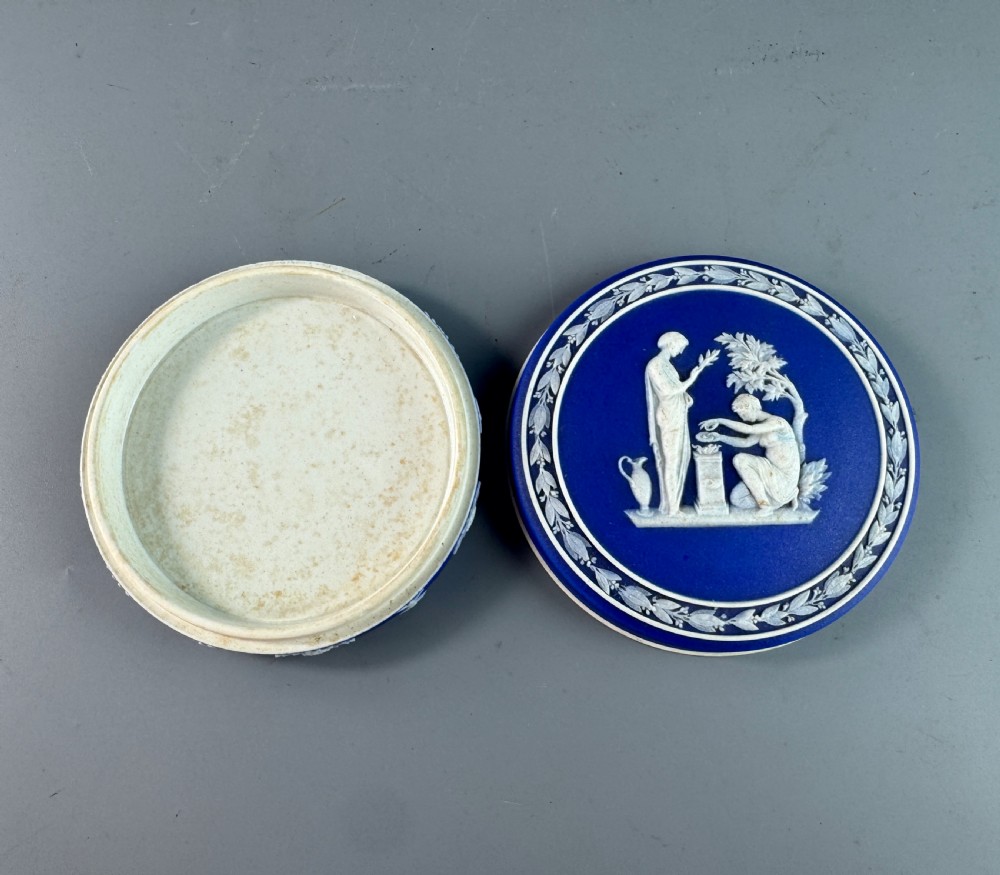 A circular royal blue jasperware patch box featuring white neoclassical relief figures on the lid and floral sprigging around the rim. View VI