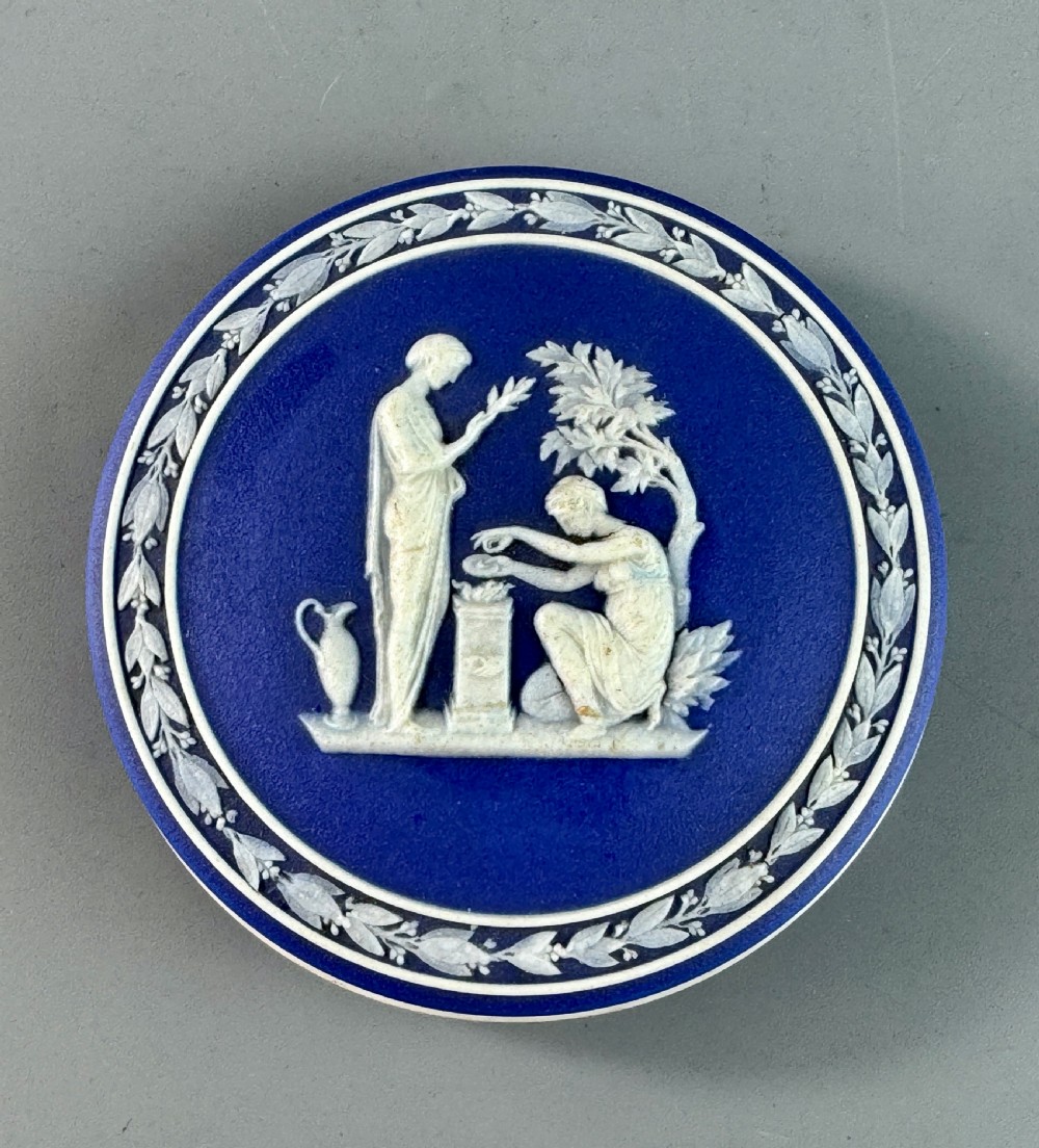 A circular royal blue jasperware patch box featuring white neoclassical relief figures on the lid and floral sprigging around the rim. View VII