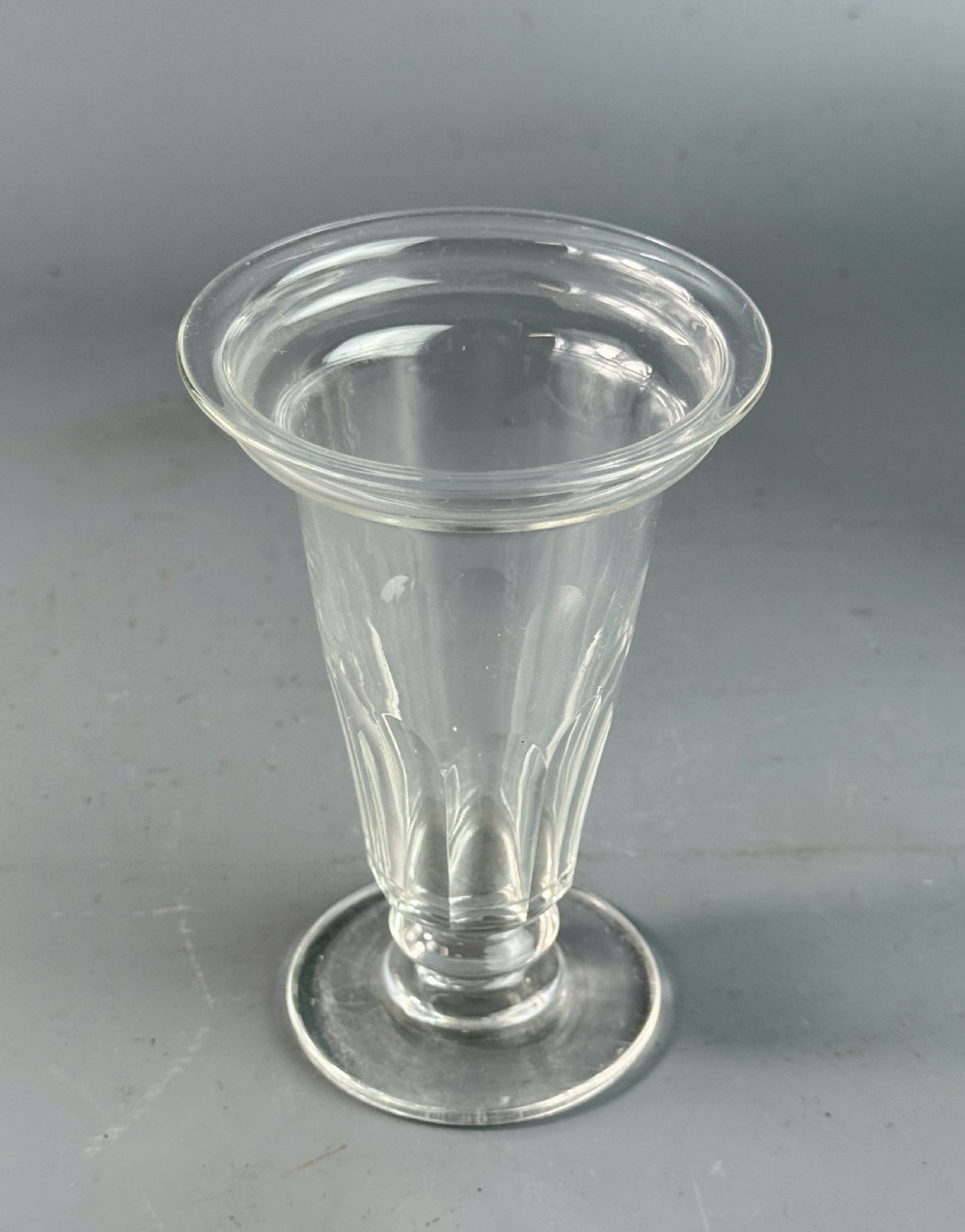 A set of six clear Georgian glass jelly cups featuring fluted tapered bowls, dish tops, knopped stems, and circular bases. View VI