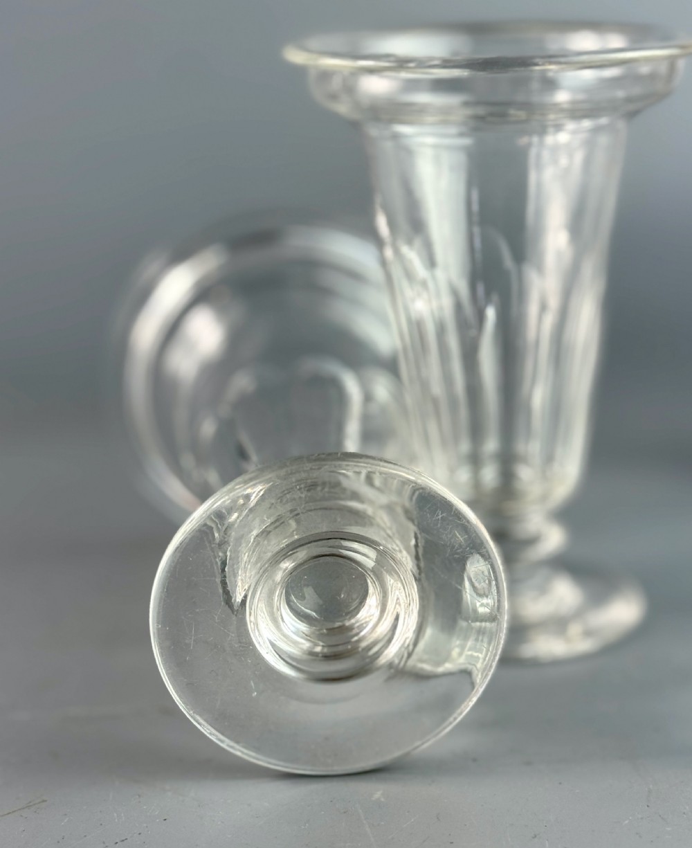 A set of six clear Georgian glass jelly cups featuring fluted tapered bowls, dish tops, knopped stems, and circular bases. View VII