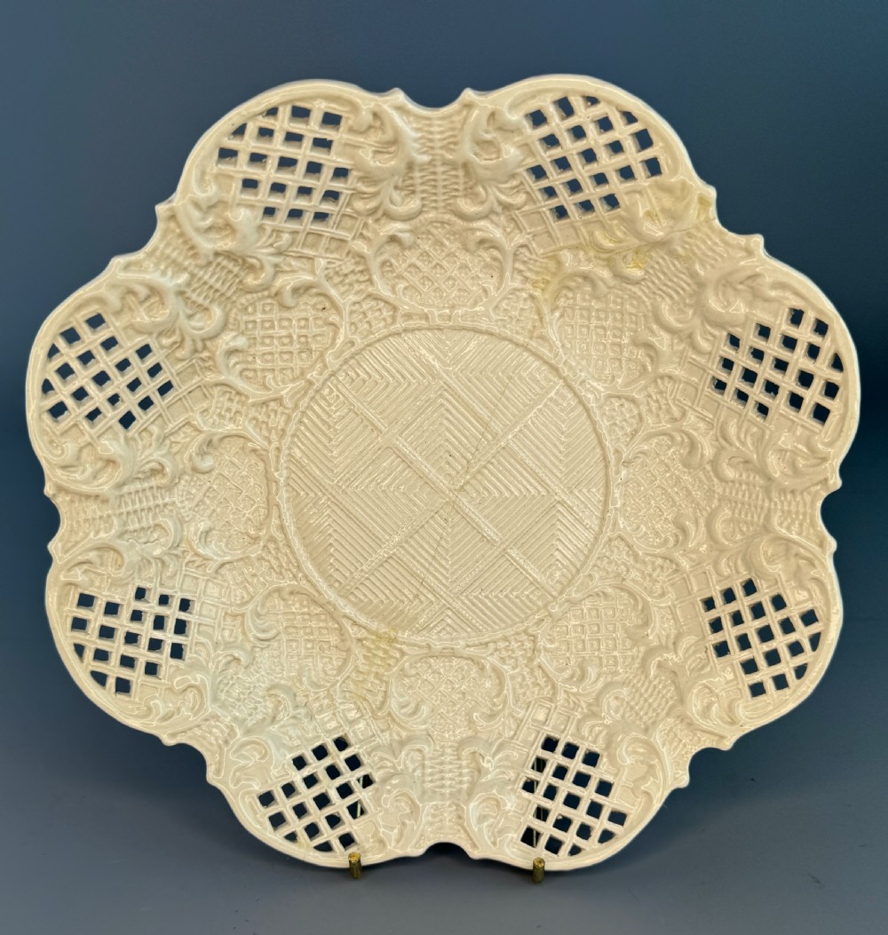 An 18th-century cream-coloured Staffordshire saltglaze stoneware lobed plate featuring lattice piercing and relief-moulded scrollwork details. View II