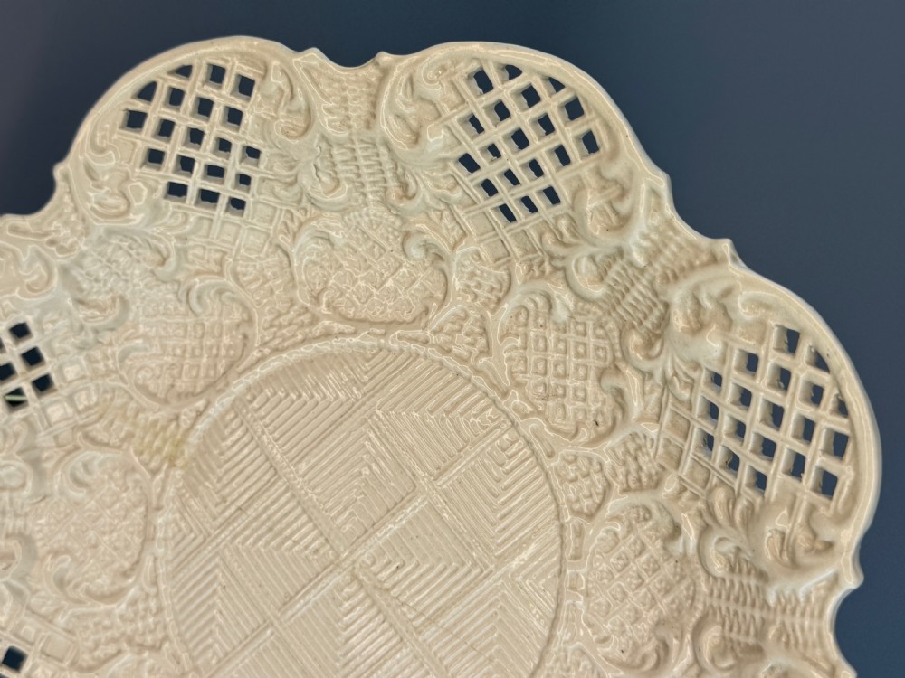 An 18th-century cream-coloured Staffordshire saltglaze stoneware lobed plate featuring lattice piercing and relief-moulded scrollwork details. View III