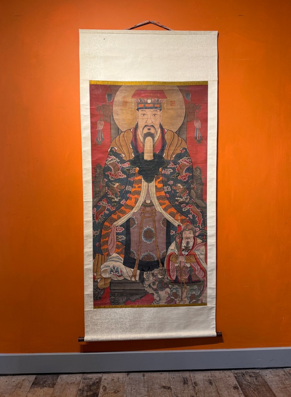 A Chinese vertical hanging scroll depicting the Daoist Jade Emperor in ceremonial robes seated on a throne alongside an attendant.