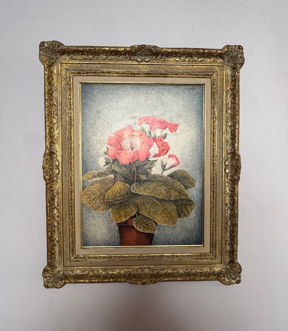 A framed botanical still life drawing depicting a gloxinia plant in a pot, executed in pen and coloured ink within an ornate gilded frame.