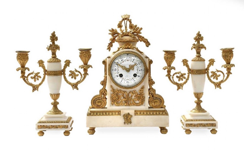 A late 19th-century French gilt bronze and white marble mantel clock garniture set flanked by two matching two-light candelabra. View VI