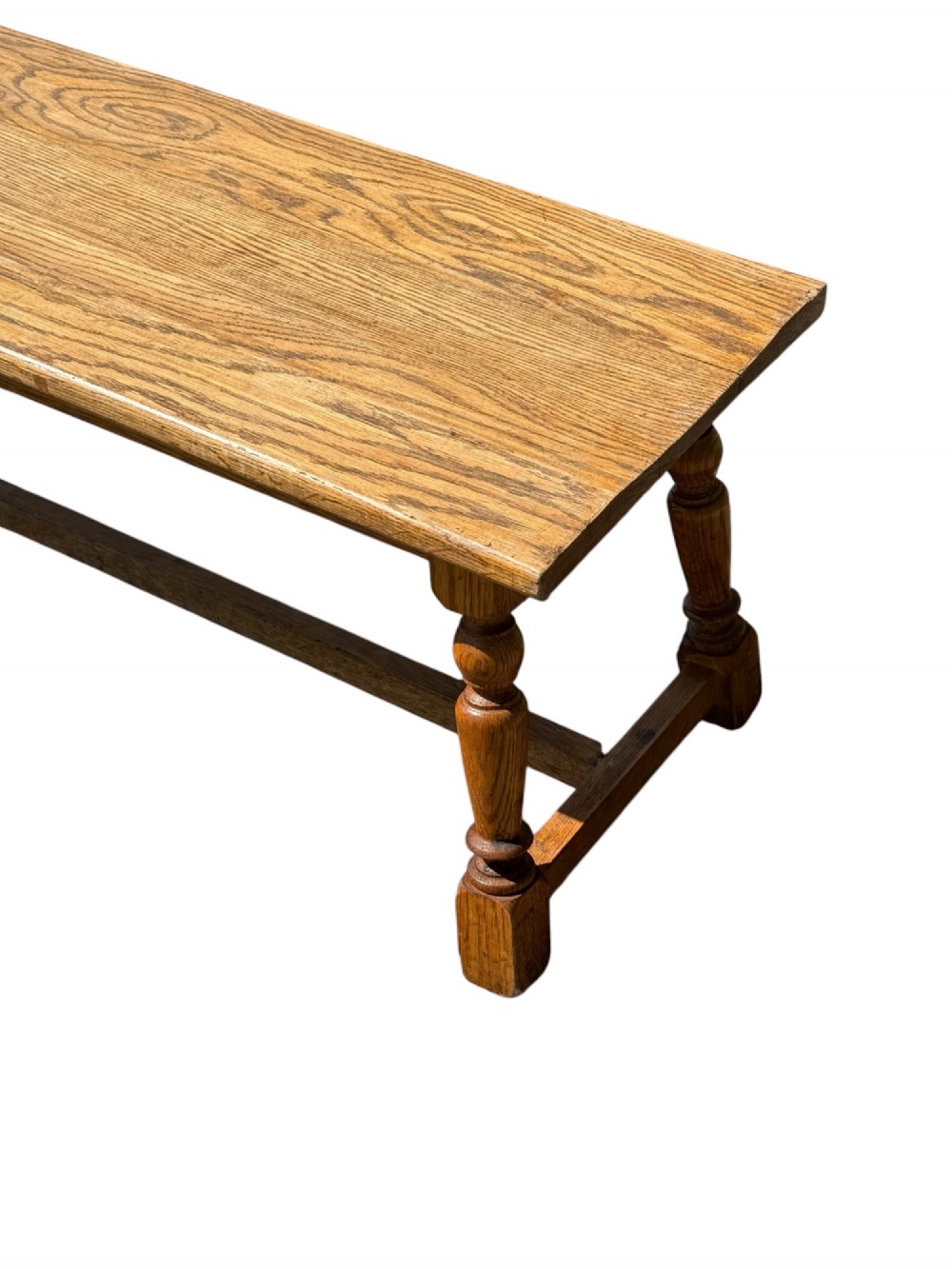 An exceptionally long rustic antique oak bench featuring a smooth rectangular seat, turned legs, and low connecting stretchers. View IV