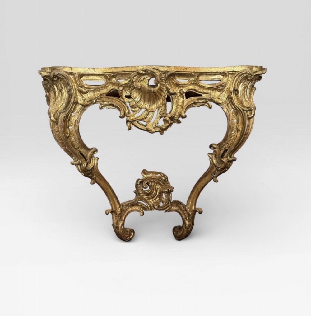 An antique Louis XV style console table featuring an intricately carved gold giltwood base with shell motifs and a contoured variegated marble top. View III