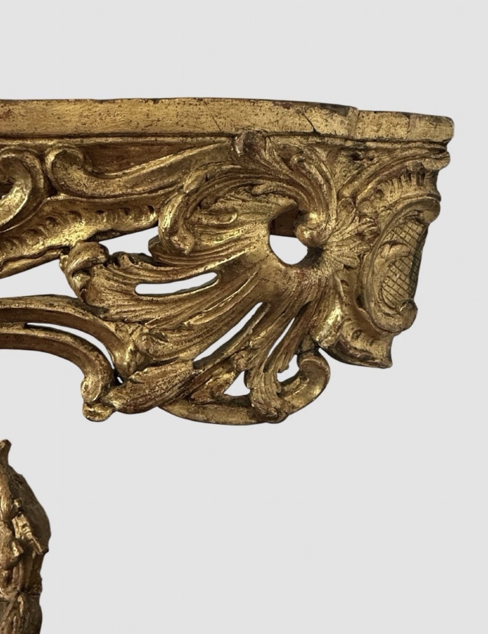 An antique Louis XV style console table featuring an intricately carved gold giltwood base with shell motifs and a contoured variegated marble top. View VI