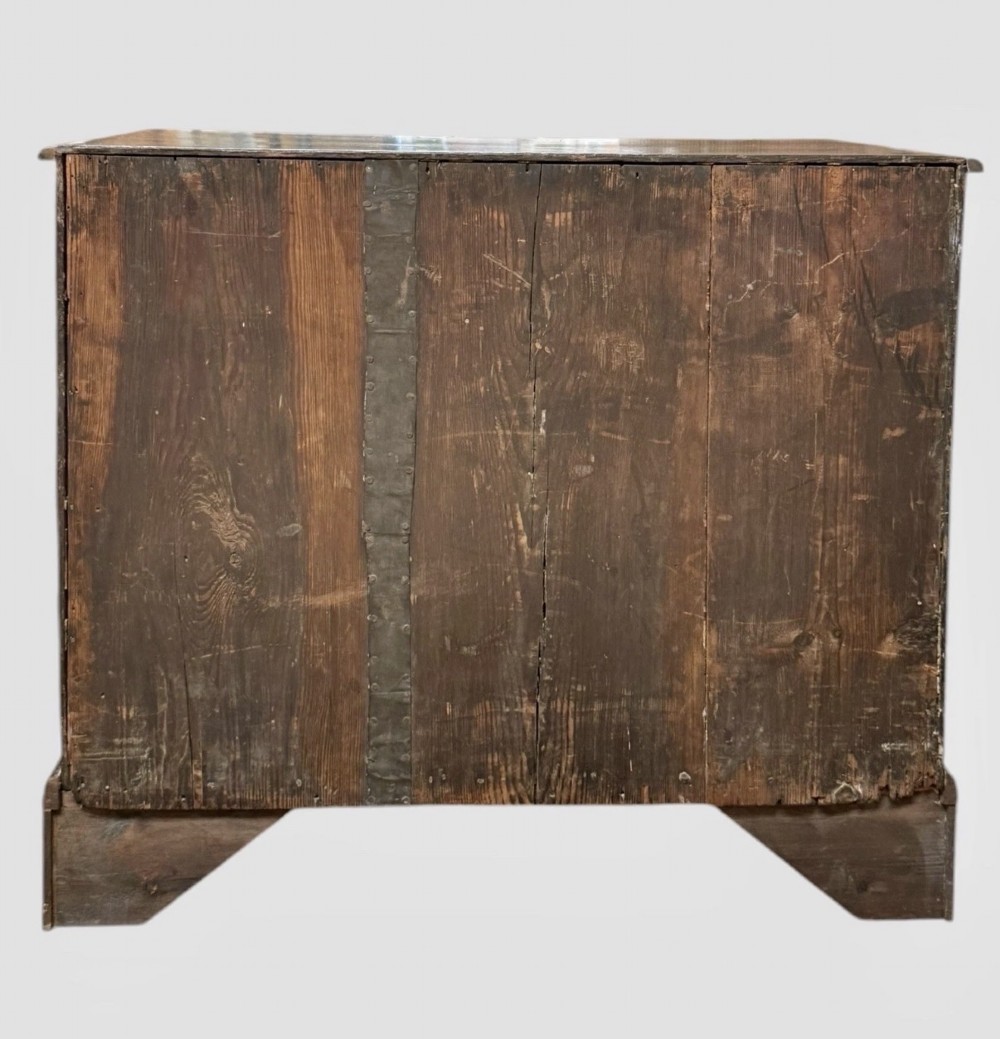 An eighteenth century dark oak chest of drawers featuring two short drawers over two long drawers with turned wooden knobs and bracket feet. View V