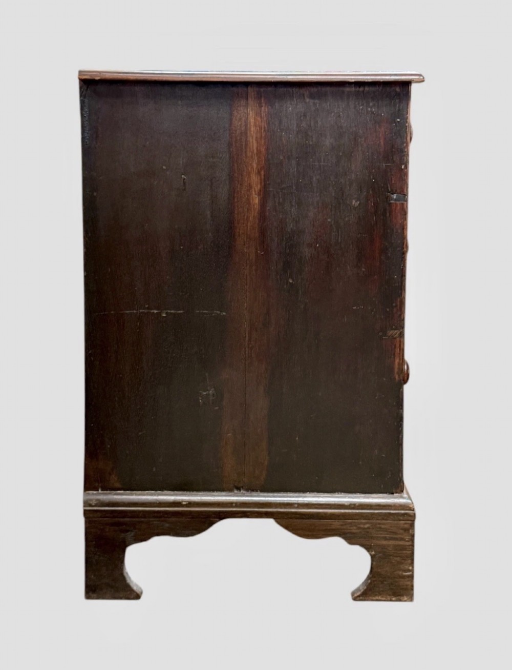 An eighteenth century dark oak chest of drawers featuring two short drawers over two long drawers with turned wooden knobs and bracket feet. View VII