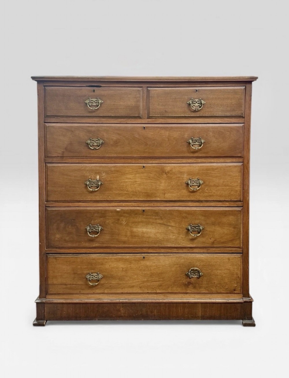 A tall Victorian mahogany chest of drawers featuring two short drawers above four long drawers with brass drop handles and a plinth base.