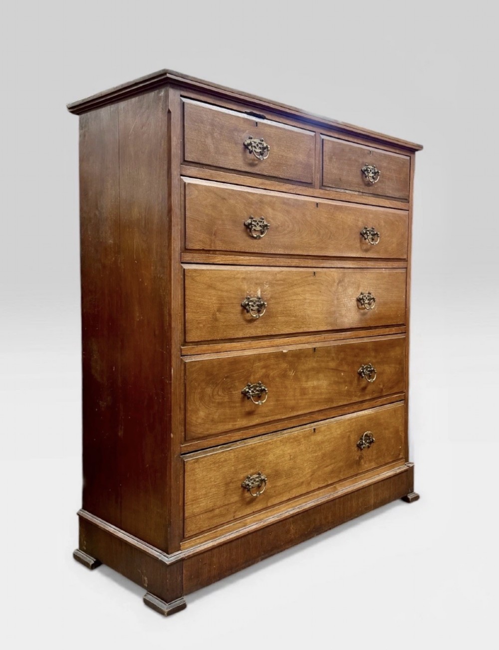 A tall Victorian mahogany chest of drawers featuring two short drawers above four long drawers with brass drop handles and a plinth base. View II