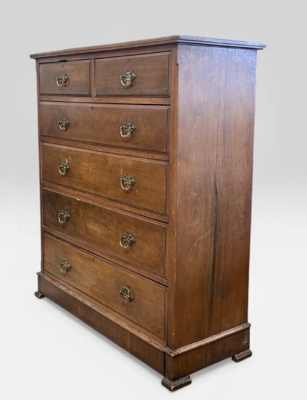 A tall Victorian mahogany chest of drawers featuring two short drawers above four long drawers with brass drop handles and a plinth base. View III