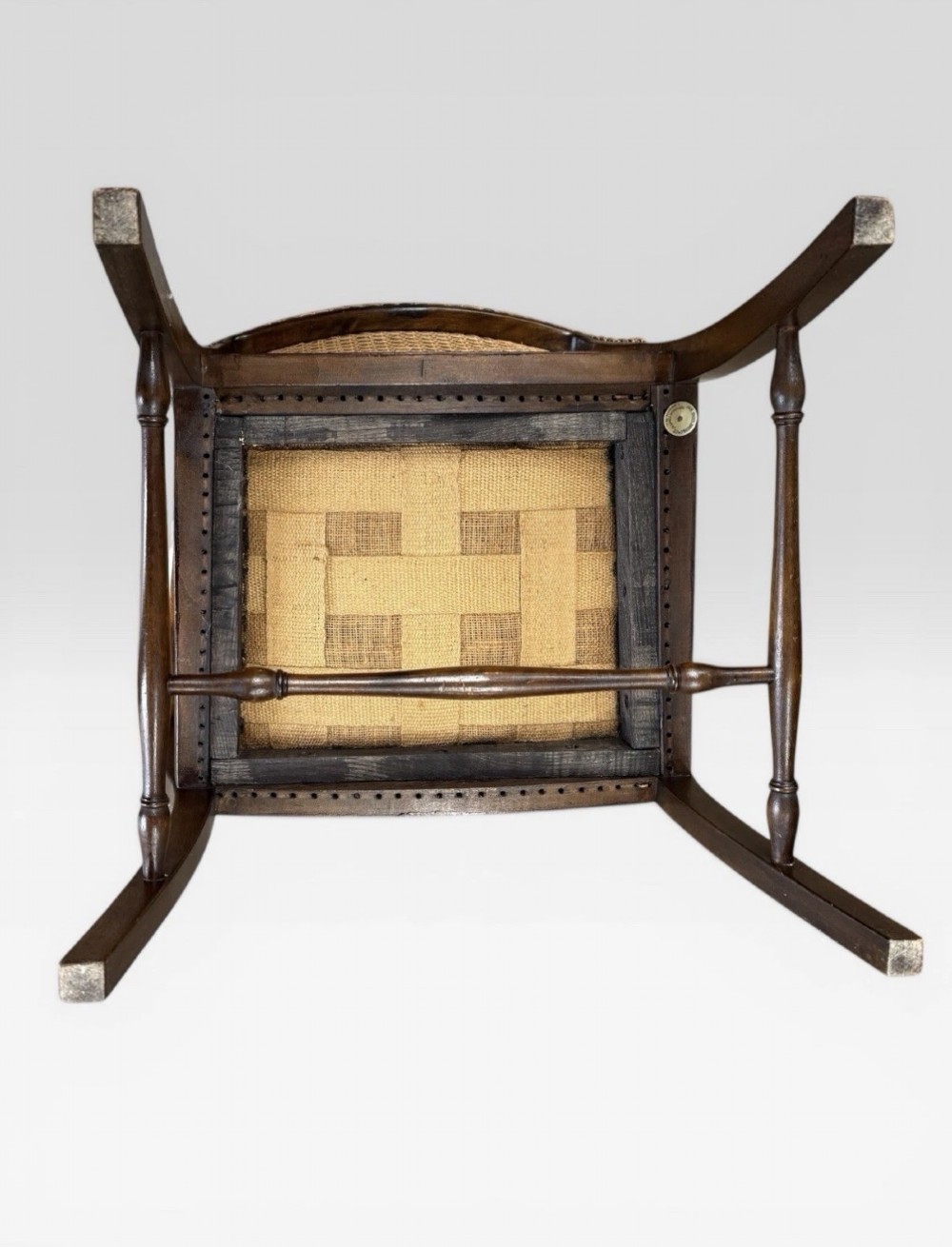 An antique childs wooden armchair featuring a cane woven backrest, swept armrests, turned stretchers, and a red velvet upholstered drop-in seat. View VII