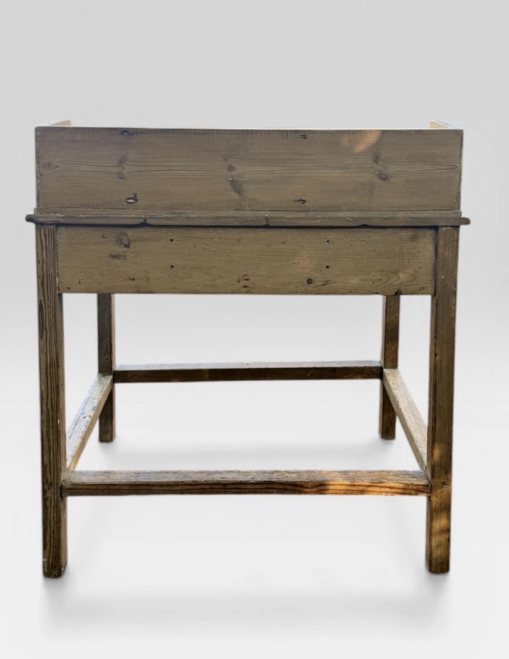 A nineteenth-century Victorian natural pine washstand featuring a raised splashback gallery, a single front drawer with brass handles, and square legs joined by a box stretcher. View VI