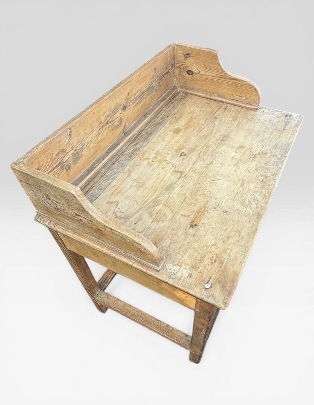 A nineteenth-century Victorian natural pine washstand featuring a raised splashback gallery, a single front drawer with brass handles, and square legs joined by a box stretcher. View VII