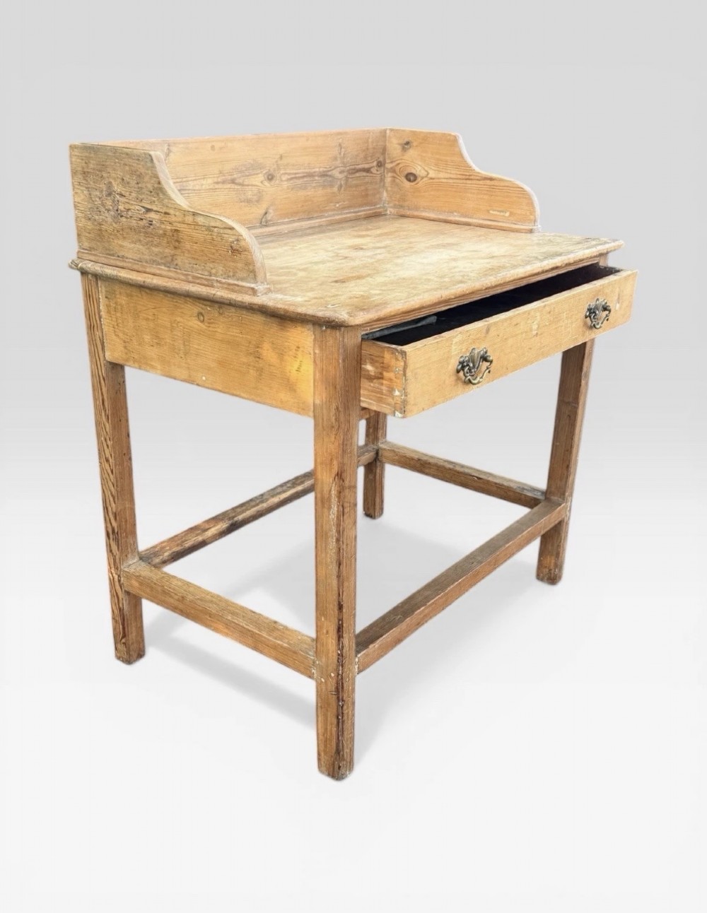 A nineteenth-century Victorian natural pine washstand featuring a raised splashback gallery, a single front drawer with brass handles, and square legs joined by a box stretcher. View VIII