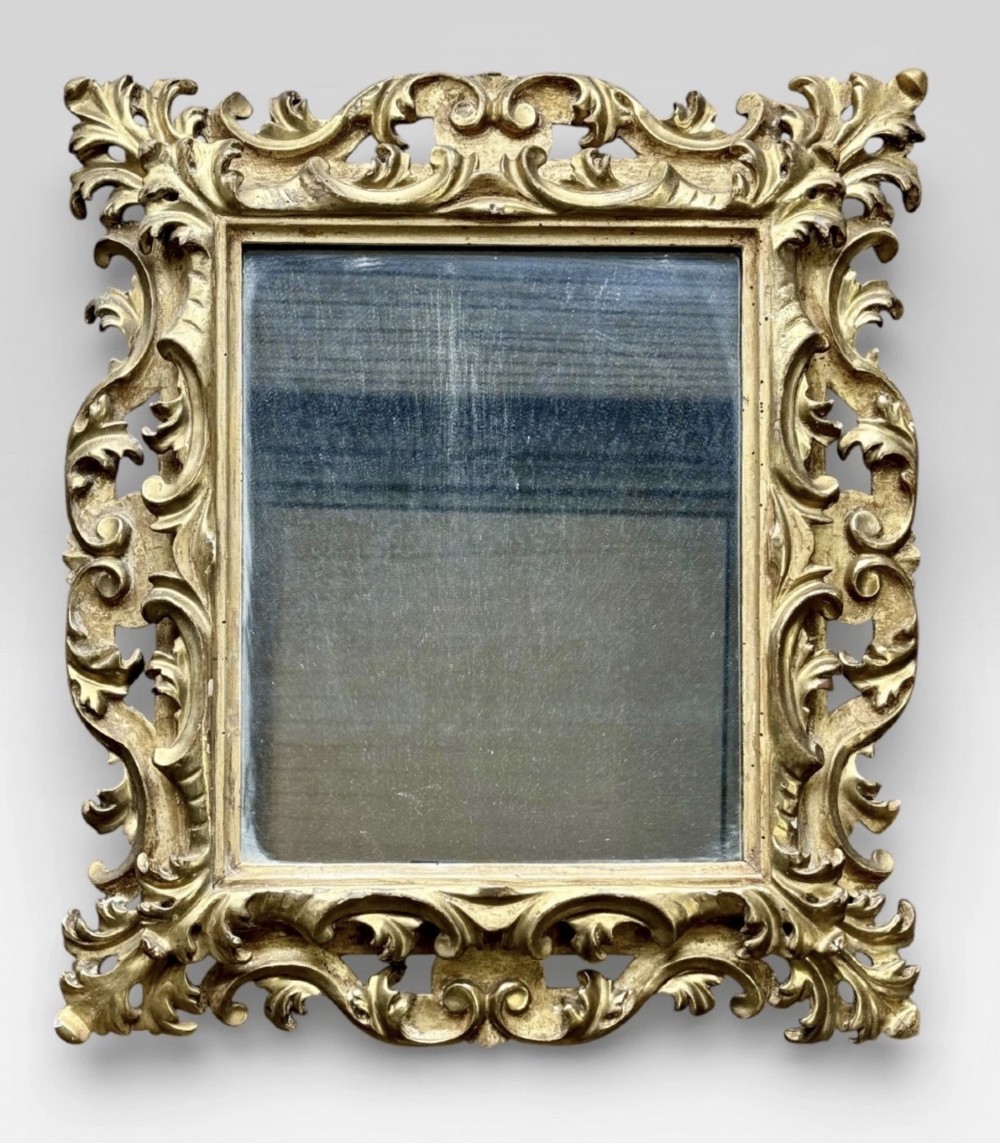 A pair of 19th-century rectangular Florentine wall mirrors featuring intricately carved giltwood frames with openwork scroll and acanthus leaf details. View II