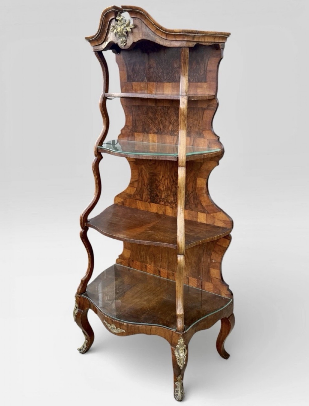A nineteenth-century walnut etagere featuring open serpentine shelves, patterned wood veneers, ornate gilt metal mounts, and cabriole legs. View III