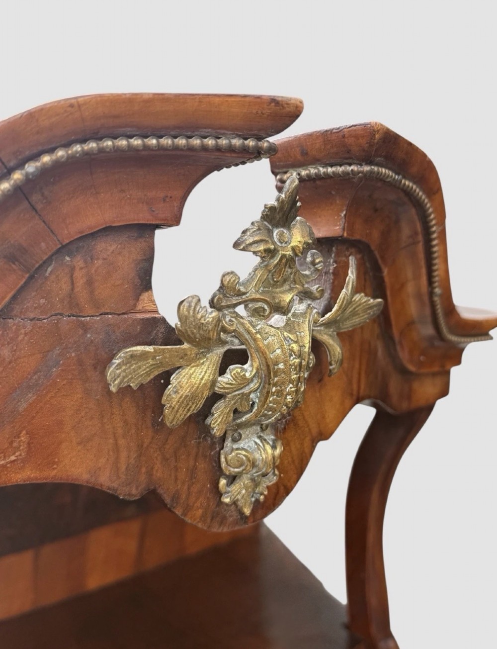 A nineteenth-century walnut etagere featuring open serpentine shelves, patterned wood veneers, ornate gilt metal mounts, and cabriole legs. View VII