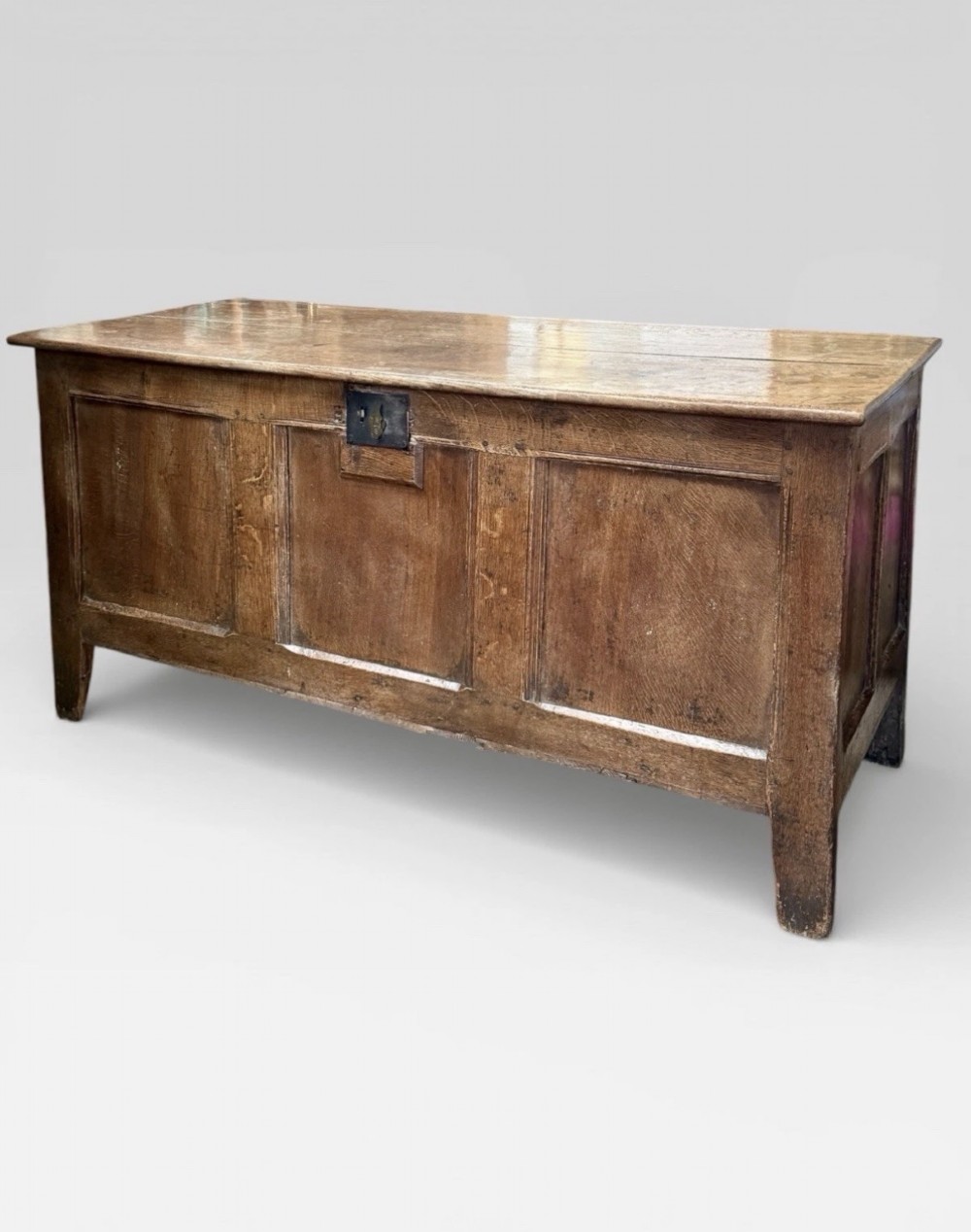 An antique 18th-century oak coffer featuring a three-panel front design and a central iron escutcheon lock plate. View III