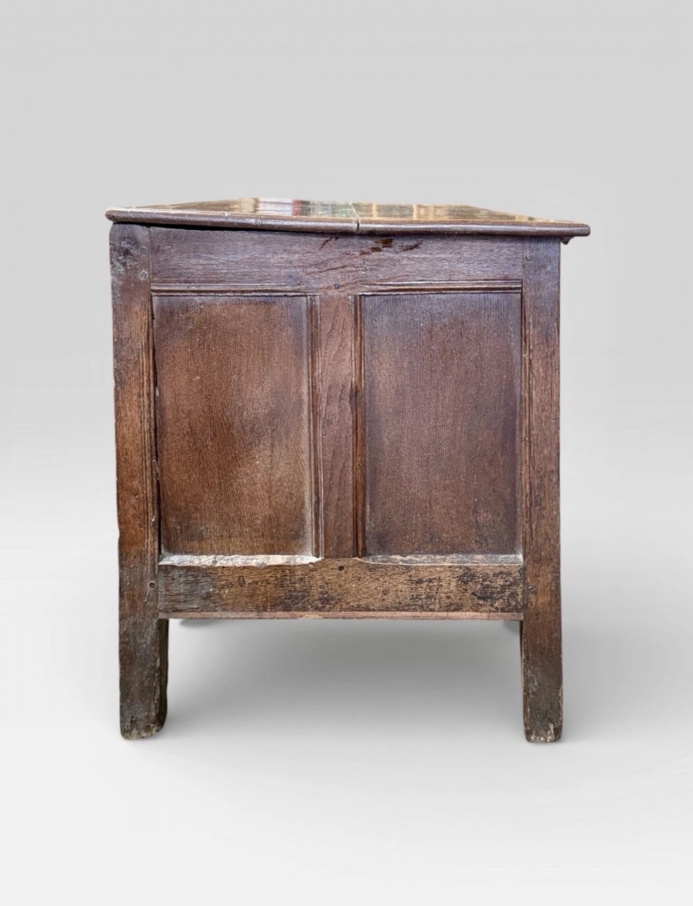 An antique 18th-century oak coffer featuring a three-panel front design and a central iron escutcheon lock plate. View IV