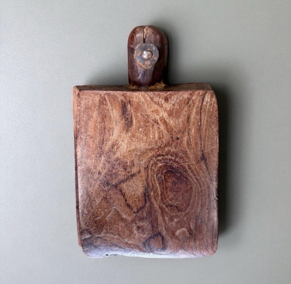 A hand-carved warm brown wooden spice box featuring a smooth grain finish and a pivoting lid held by a single metal rivet. View IV