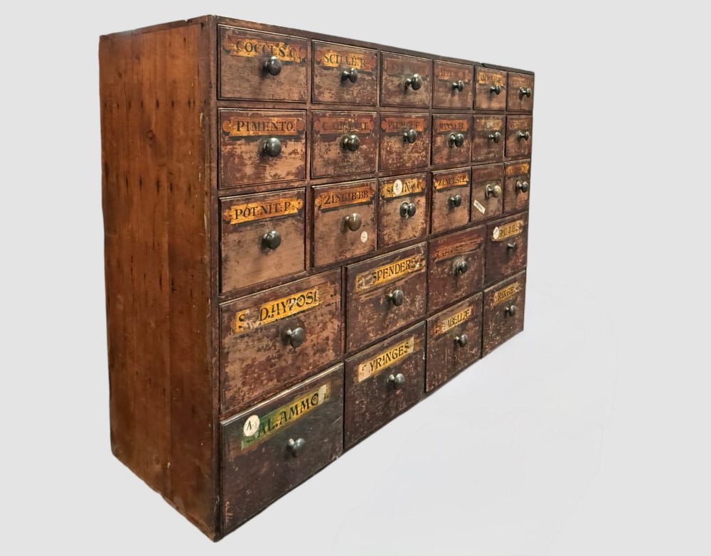 A 19th-century dark wood apothecary bank of drawers featuring twenty-six individual drawers with Latin botanical labels and turned knob handles. View III